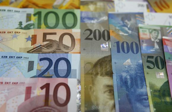 File photo illustration of various Euro banknotes lying next to various Swiss Franc banknotes