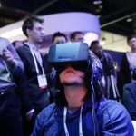 show attendees play a video game wearing Oculus Rift virtual reality headsets