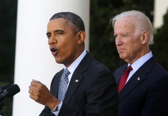U.S. President Barack Obama stands next to Vice President Joseph Biden while speaking about the enrolment numbers of the Affordable Care Act at the White House in Washington