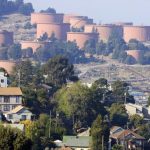 File photo of homes sitting below Chevron storage tanks on a hillside in Richmond, California