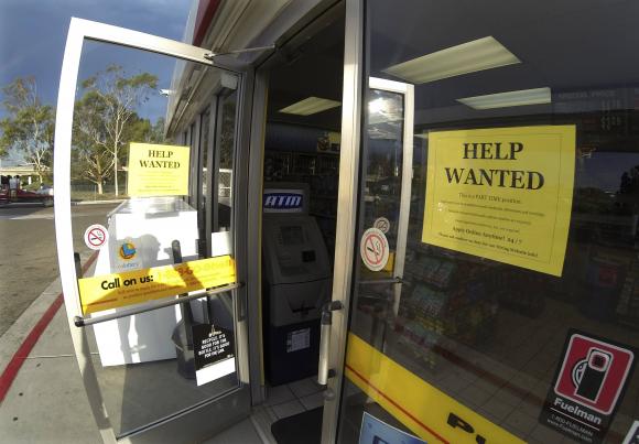 A help wanted sign is posted on the door of a gas station in Encinitas, California