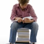 Boy Sitting On Books