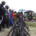 Militants from the Democratic Forces for the Liberation of Rwanda (FDLR) stand near a pile of weapons after their surrender in Kateku