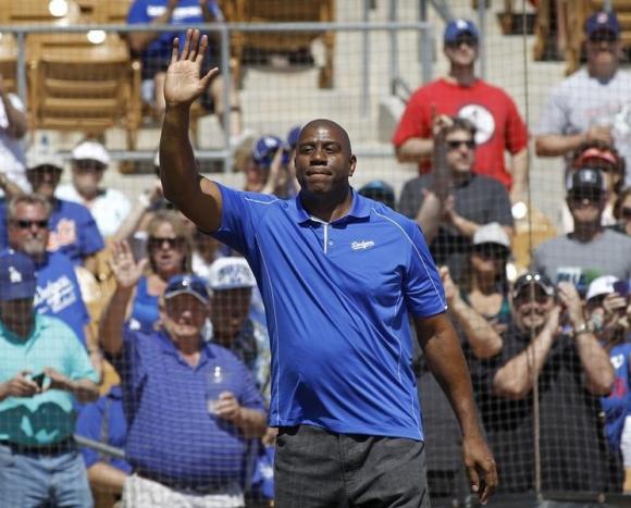 Los Angeles Dodgers co-owner Earvin Magic Johnson acknowledges the crowd before MLB Cactus League spring training baseball game against the Cincinnati Reds in Glendale