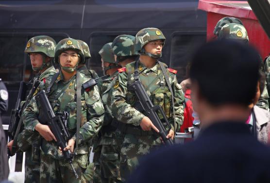 Paramilitary policemen stand guard near the exit of the South Railway Station in Urumqi