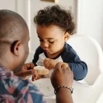 A man feeding baby.