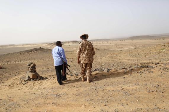 A Libyan soldier and a member of a security unit patrol the desert border between Libya and Algeria