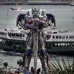 A giant Transformer figure is displayed against Victoria Harbor in Hong Kong