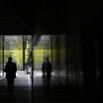 Man using a mobile phone walks down a corridor of a building at a business district in Tokyo