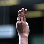 A protester flashes three fingers, representing liberty