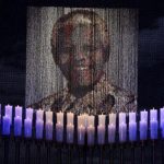 Candles are lit under a portrait of former South African President Mandela before his funeral ceremony in Qunu