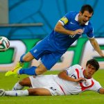 Costa Rica's Yeltsin Tejeda (bottom) fouls Greece's Giorgos Karagounis