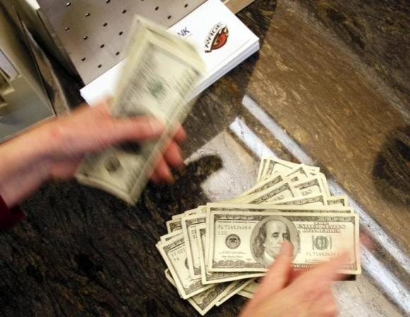 Four thousand U.S. dollars are counted out by a banker counting currency at a bank in Westminster