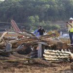 Investigators look over the scene of a double fatality accident Monday