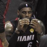 Miami Heat's LeBron James sits on the bench during a timeout against the San Antonio Spurs during second quarter Game 5 NBA Finals in San Antonio