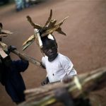 Muslim refugee children carry firewood
