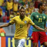 Brazil's Neymar celebrates past Cameroon's Joel Matip after scoring a goal during their 2014 World Cup Group A soccer match at the Brasilia national stadium in Brasilia