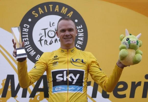 Team Sky rider and Tour de France winner Christopher Froome of Britain holds a trophy and a stuffed toy on a podium during a victory ceremony in Saitma