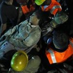 an injured woman worker pulled out from the rubble of a building