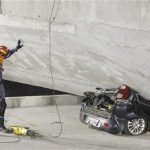 A policeman looks at a car crushed underneath a collapsed bridge in Belo Horizonte