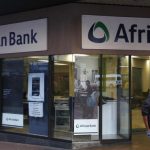 A man walks past a branch of African Bank in Cape Town