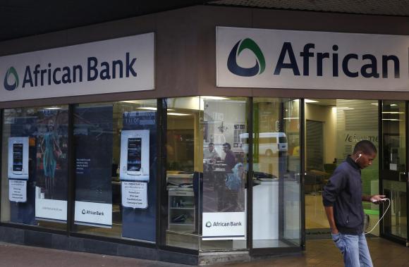 A man walks past a branch of African Bank in Cape Town