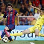 Barcelona's Lionel Messi, from Argentina, challenges for the ball with Villarreal's Grabiel Paulista