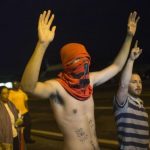 Demonstrators shout "Hands up, don't shoot," while protesting the killing of unarmed black teen Michael Brown in Ferguson, Missouri