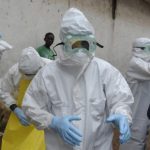 Health workers wearing protective clothing prepare to carry an abandoned dead body presenting with Ebola symptoms at Duwala market in Monrovia