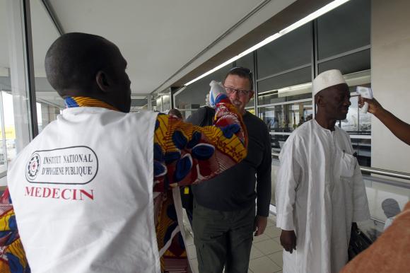 Health workers take passengers' temperatures infrared digital laser thermometers at the Felix Houphouet Boigny international airport in Abidjan