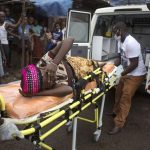 A pregnant woman suspected of contracting Ebola is lifted by stretcher into an ambulance in Freetown