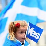 A young girl holds a flag at a 'Yes' campaign rally in Glasgow