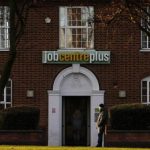 A man stands outside a state Job Centre employment office in Coalville, central England