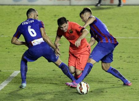 Barcelona's Lionel Messi fights for the ball with Levante's Loukas Vyntra and Tono Garcia during their Spanish first division soccer match at the Ciudad de Valencia stadium in Valencia