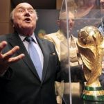 FIFA President Sepp Blatter gestures next to the World Cup trophy after a media conference in Sao Paulo