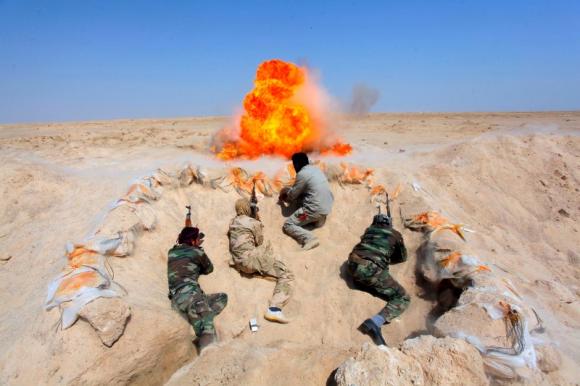 Shi'ite fighters, who have joined the Iraqi army to fight against militants of the Islamic State, formerly known as the Islamic State of Iraq and the Levant (ISIL), take part in field training in the desert in the province of Najaf