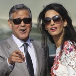 U.S. actor George Clooney and his wife Amal Alamuddin stand on a water taxi on the Grand Canal in Venice