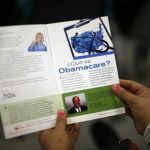 A woman reads a pamphlet in Spanish at a health insurance enrollment event in Cudahy