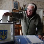 Local resident places her ballot into a mobile ballot box during a parliamentary election, at her home in Horodyshche near Chernihiv