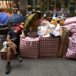A pro-democracy protester sleeps beside supplies at a make-shift logistic centre on the blocked Nathan Road at Mongkok shopping district in Hong Kong