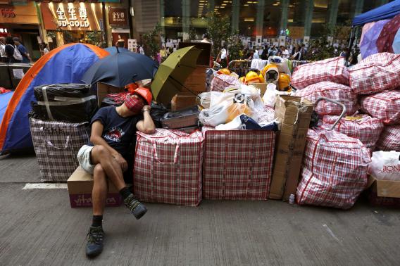 A pro-democracy protester sleeps beside supplies at a make-shift logistic centre on the blocked Nathan Road at Mongkok shopping district in Hong Kong