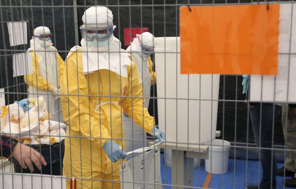 A volunteer for Medecins Sans Frontieres receives training on how to handle personal protective equipment during courses in Brussels