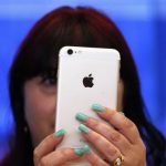 A woman holds an iPhone 6 Plus after it went on sale at the Apple store in Sydney