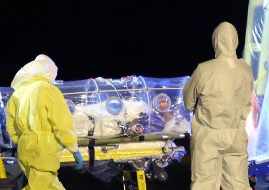 Health workers load Spanish Ebola patient, Catholic priest Garcia Viejo, into an ambulance on the tarmac of Torrejon airbase