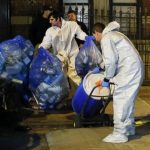 Members of a cleaning crew with "Bio Recovery Corporation" push a barrel to be loaded in a truck of Centers for Disease Control and Prevention after cleaning the apartment where Dr. Craig Spencer lives in