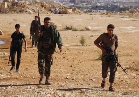 Rebel fighters carry their weapons as they move towards their positions at the frontline against forces of Syria's President Assad in the Handarat area