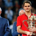 Tournament director Brennwald stands beside as Switzerland's Federer holds the trophy after winning his final match against Belgium's Goffin at the Swiss Indoors ATP tennis tournament in Basel