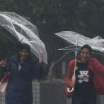 Passers-by with umbrellas struggle against strong winds and heavy rain caused by Typhoon Phanfone, in Tokyo