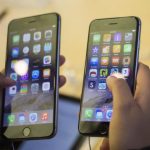A customer holds an iPhone 6 and iPhone 6 Plus after the phones went on sale at the Fifth Avenue Apple store in Manhattan, New York