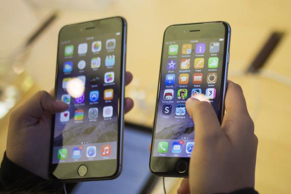 A customer holds an iPhone 6 and iPhone 6 Plus after the phones went on sale at the Fifth Avenue Apple store in Manhattan, New York